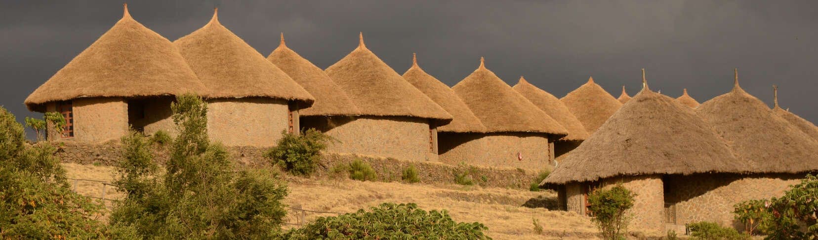 Simien Lodge’s tukuls under a stormy sky