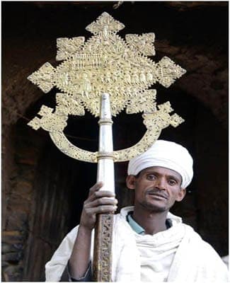 Priest holding a silver processional cross