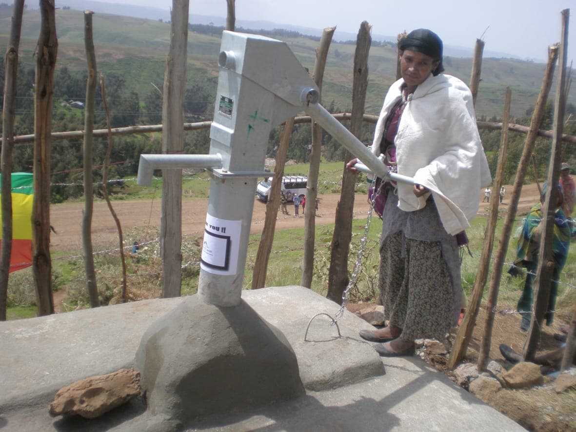 Woman at a new hand-pump water well