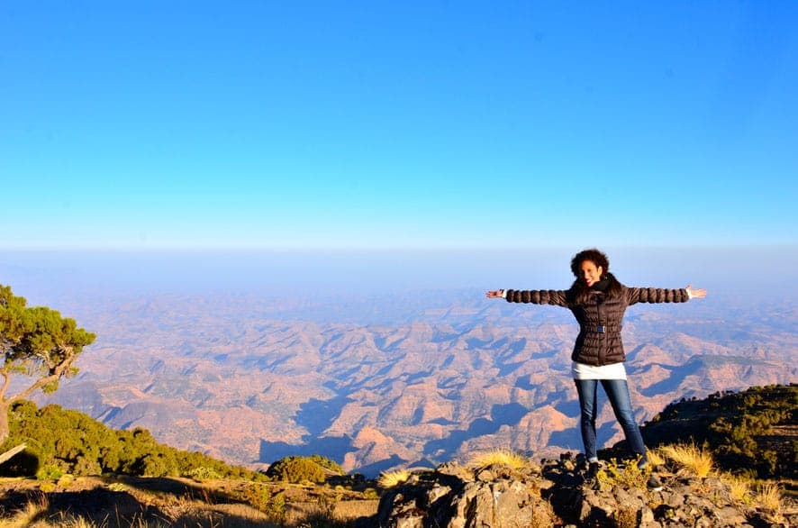Visitor with outstretched arms above the Simien Mountains