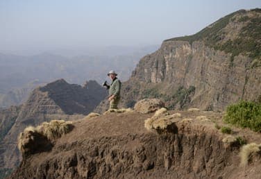 Trekker on a clifftop above a deep valley