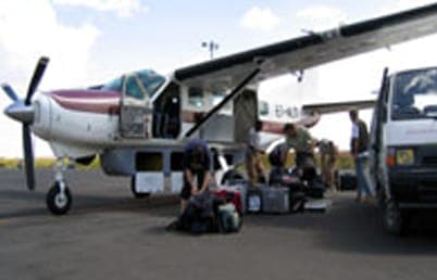 Passengers loading bags into a light aircraft