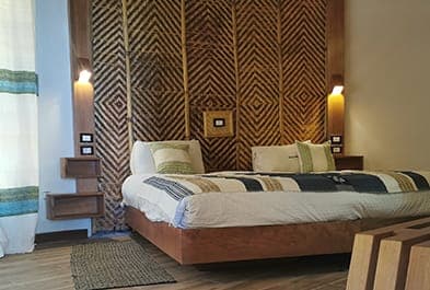 Main room with a woven headboard and wooden floor